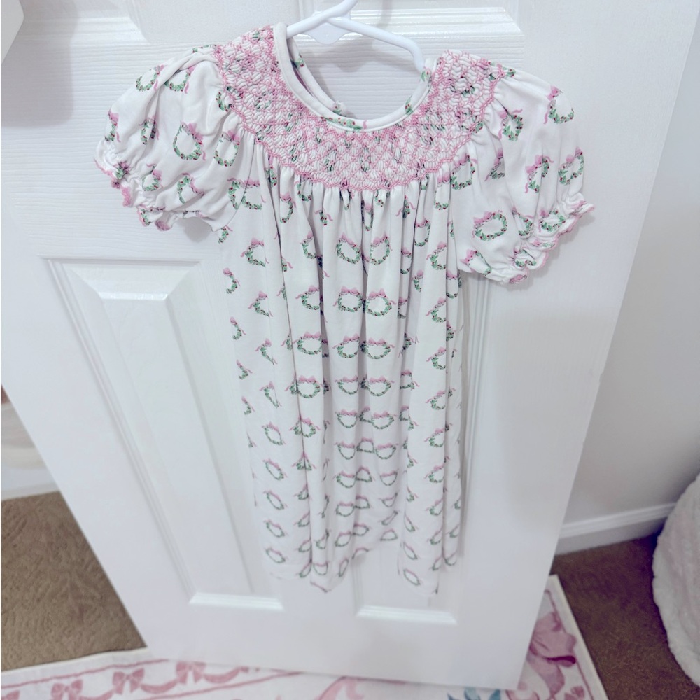 Petit Bebe. Sister match available in closet. Wreath smocked.